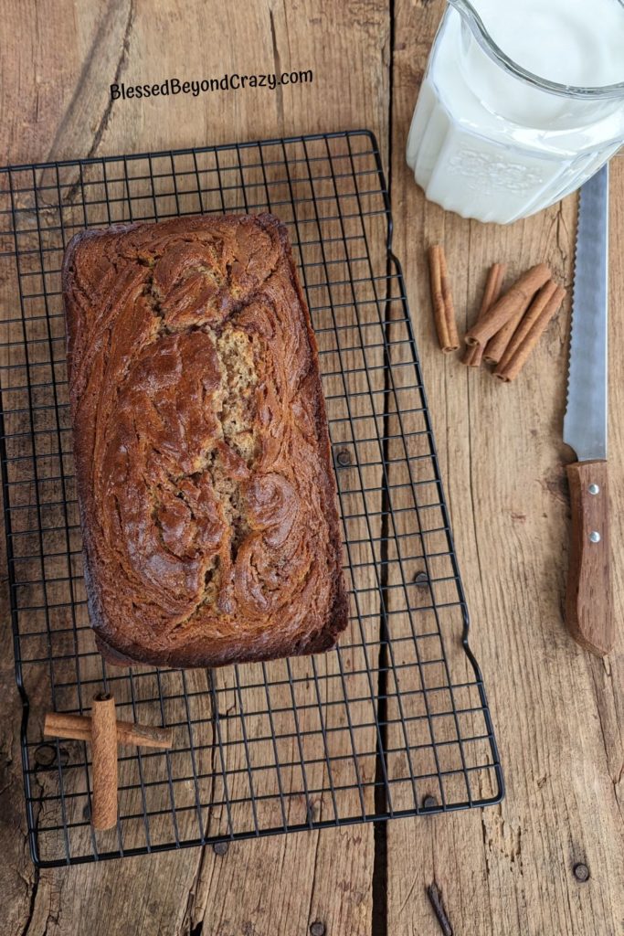 Cinnamon Swirl Coffee Cake Loaf cooling on a black wire rack.