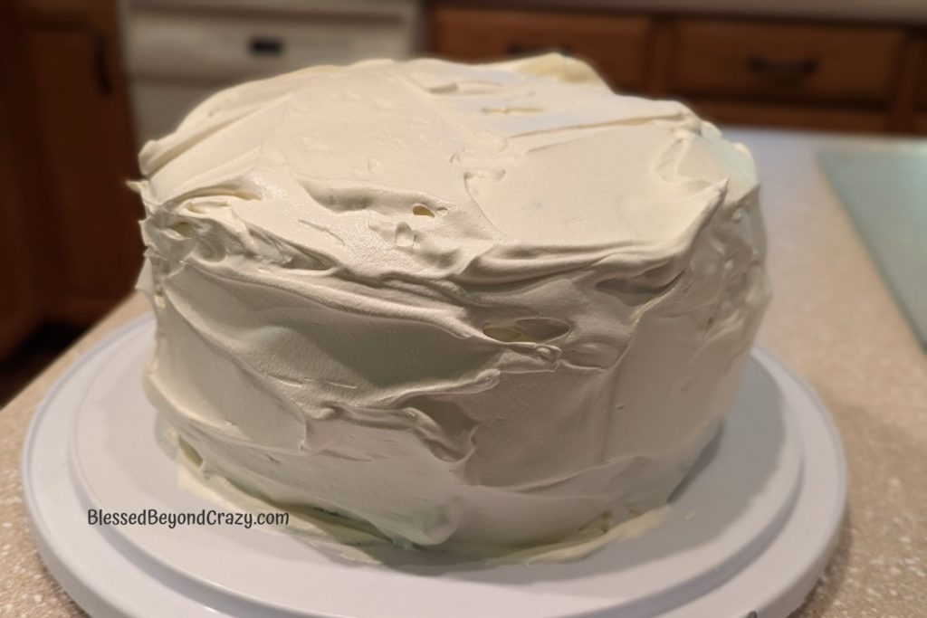 Photo of Gluten-Free Oreo Ice Cream Cake covered in whipped topping.